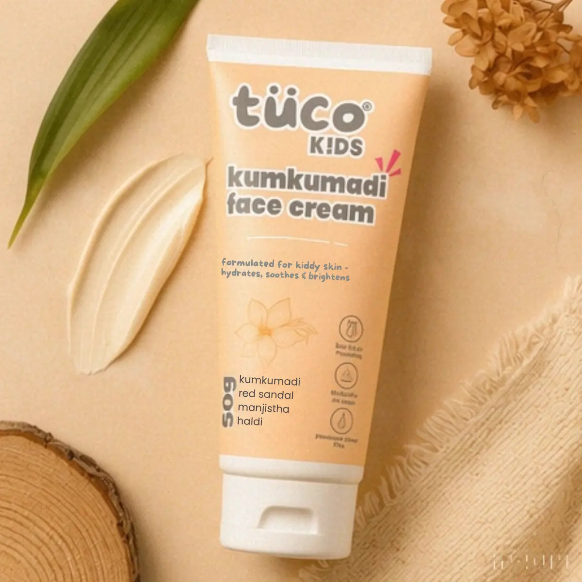 Tube of Tuco Kids Kumkumadi face cream on a beige background with natural elements.